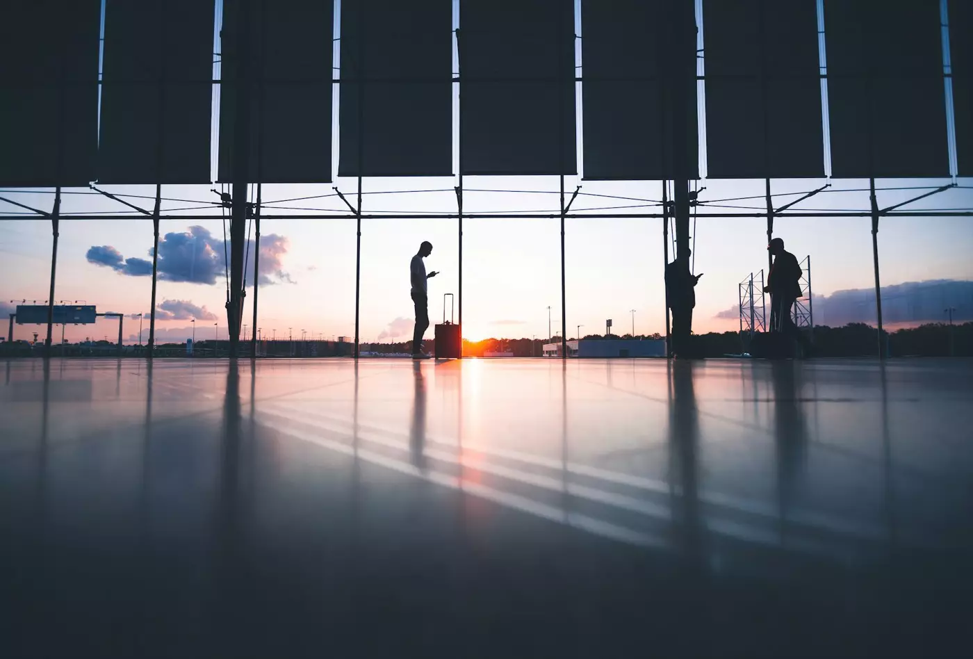 Travellers with luggage walking through an airport terminal