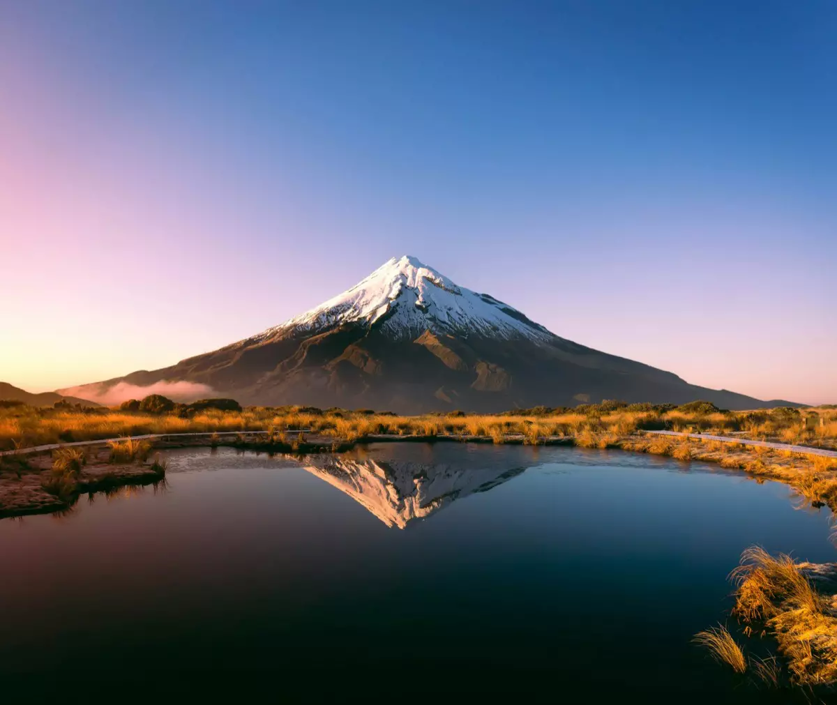 Mount Taranaki reflected in an alpine tarn at sunset